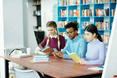 a group of people sitting at a table in a library