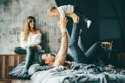 a man and woman jumping on a bed