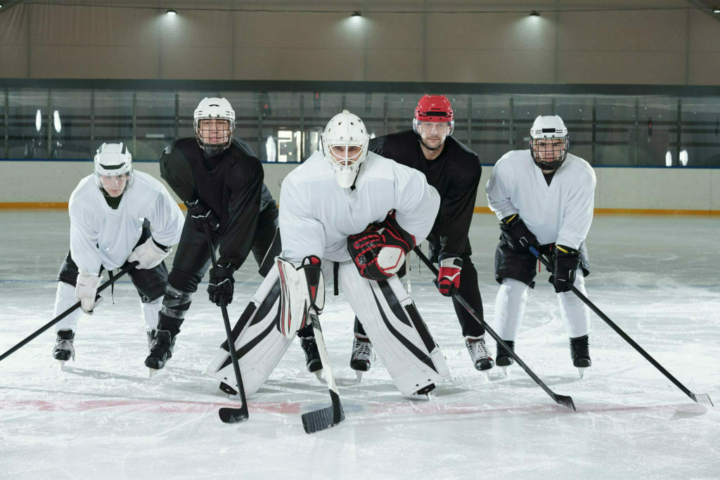 Professional hockey players bending forwards while standing on ice rink