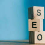 SEO word made from wooden alphabet cubes on blue background