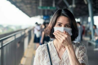 Asian woman wearing face mask for prevent dusk pm 2.5 bad air pollution and coronavirus or covid19